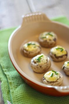 small appetizers are sitting in a dish on a green cloth next to a fork