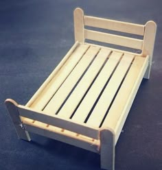 a small wooden bed with slats on the bottom and sides, made out of plywood