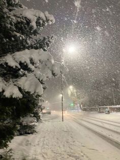 the street is covered in snow at night