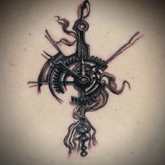 a clock tattoo on the back of a woman's shoulder and neck, with scissors in it