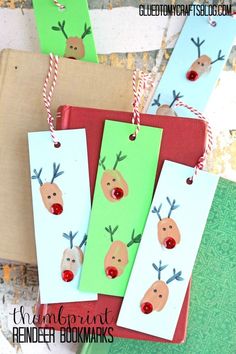 three bookmarks with reindeer faces on them hanging from twine strings and paper tags