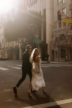 a bride and groom walking across the street