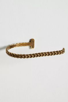 a gold colored bracelet with a metal hook on the end and a chain attached to it