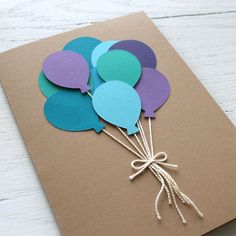 some balloons are tied to a brown card