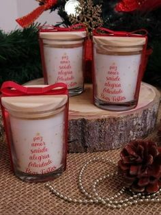 three candles sitting on top of a table next to a pine cone and christmas tree