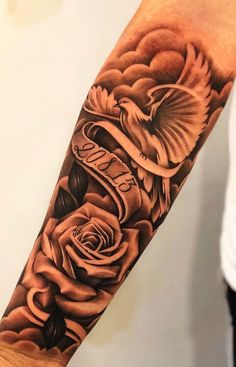 a man's arm with roses and an eagle tattoo on the left side of his arm