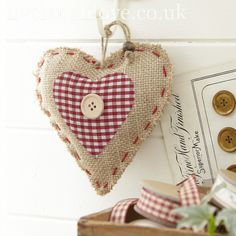 a heart shaped burlock hanging on a wall next to buttons and other items