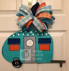 a blue camper door hanger with a bow on it