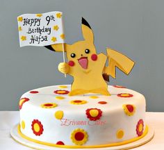 a birthday cake decorated with a pikachu holding a happy 6th birthday sign