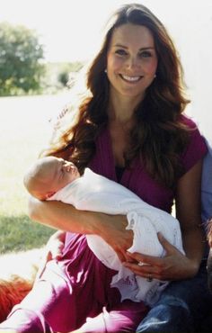 a man and woman sitting on a bench holding a baby with a dog in front of them