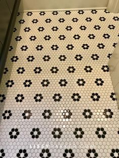 a bathroom with black and white tiles on the floor