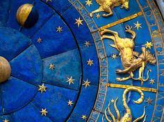 an ornate blue and gold clock with zodiac signs on it