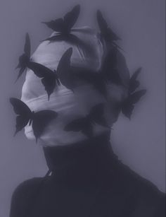 a woman with butterflies on her head in black and white, against a gray background