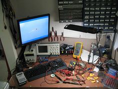 a desk with many electronics and tools on it