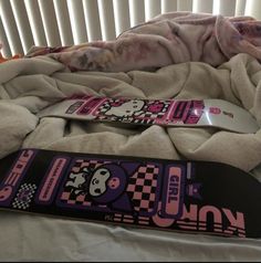 a snowboard laying on top of a bed next to a blanket and pillow cover