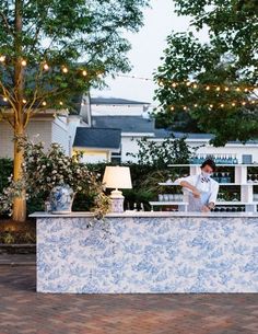 a man standing at the bar in front of some trees