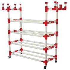 a rack with red and white pipes attached to the top of it, on wheels