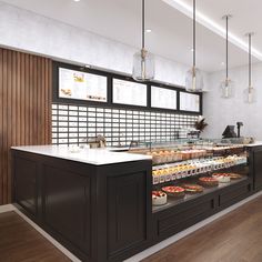 a bakery with lots of food on display in front of the counter and lights hanging from the ceiling