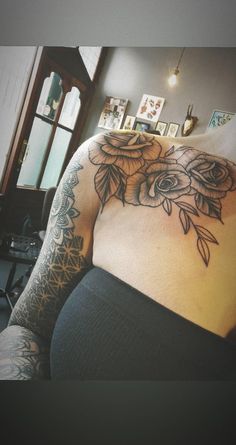 a woman with tattoos on her back and shoulder