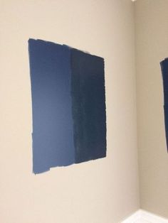 two blue paint samples are on the wall next to each other in a room with white walls