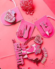 some pink items are laying out on a table with beads and other things to make it look like they have been made from paper