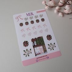 a pink and white sticker with flowers on it next to some cotton candy balls