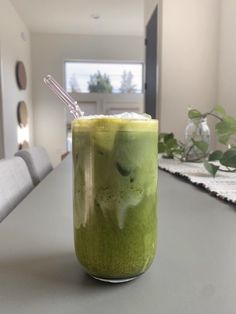 a green drink sitting on top of a table