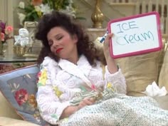 a woman sitting in a chair holding up a sign that says ice cream on it