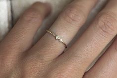 a close up of a person's hand with a diamond ring on their finger