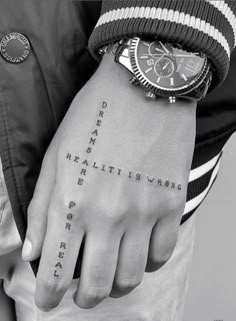 a person with a wrist tattoo that says,'real estate is visible for all to see '