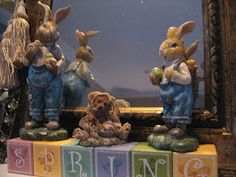 a group of bunny figurines sitting on top of blocks in front of a mirror