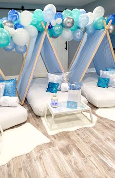 a room decorated with blue and white balloons