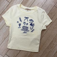 Cream Baby Tee With Embroidered Icons Cricut Graphic Tee Ideas, Disney Baby Tee, Funny Baby Tees Y2k, Embroidered Shirt Ideas, Bachelorette Tulum, Burrr Basket, Baddie Christmas, Embroidered Tshirts, Cute Baby Tees