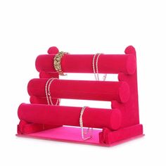 a pink jewelry holder with three rings on it