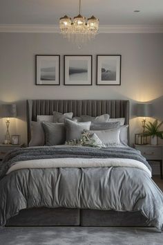 a bedroom with gray walls and pictures on the wall above the bed, along with two lamps