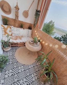 a balcony with plants and wicker furniture on the floor next to a large window