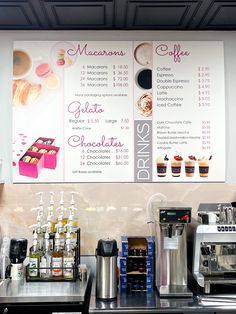 a coffee shop menu is displayed on the wall above the espresso machine and other items