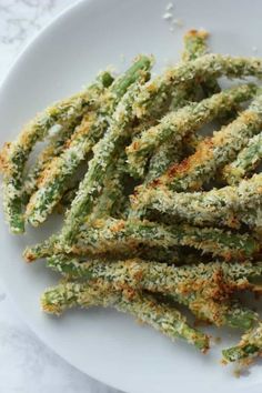 fried green beans on a white plate with parmesan sprinkles and seasoning