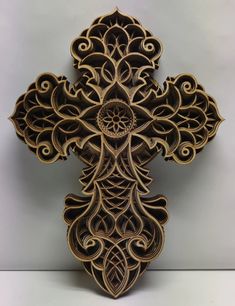 an intricately designed wooden cross is displayed on the wall in front of a white background