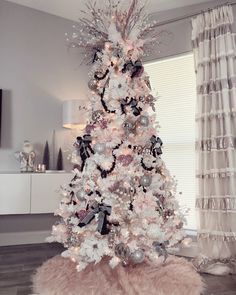 a white christmas tree with black and silver decorations