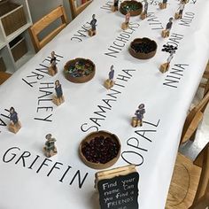 small figurines sitting on top of a table covered in writing and fruit bowls