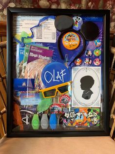 a shadow frame with mickey mouse's head, sunglasses and other items in it