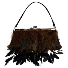 Presenting a black satin and brown feather Dolce and Gabbana evening bag. From the Fall/Winter 1997 collection, this bag debuted on the season's runway. The design is adorned with a prominent silver-tone kiss lock closure, a sleek black satin handle and body, and an exquisite combination of long and short black feathers. Whether you're attending a special event or seeking to elevate your night out, this fabulous bag is a true testament to Dolce and Gabbana's timeless elegance. Prepare to be enam Dolce And Gabbana Runway, Vintage Runway, Satin Noir, Black Feathers, Dolce & Gabbana, Black Satin, Silk Satin, Fashion Handbags, Evening Bags