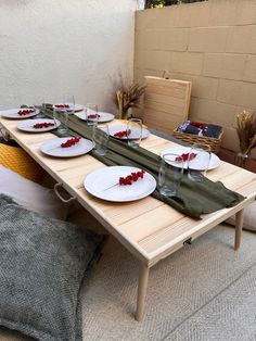 the table is set up with plates and glasses on it, ready to be served