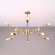 a chandelier with eight light bulbs hanging from it's center, on a gray background