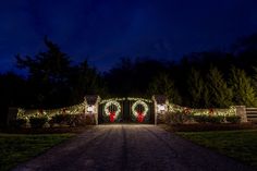 an entrance to a home decorated for christmas with lights and wreaths on the gates