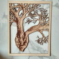 a wooden cutout of a tree on a marble wall with white and brown veining