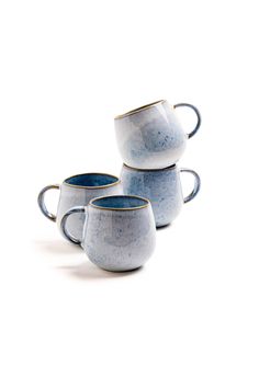 three blue and white coffee mugs sitting next to each other on a white surface