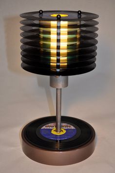 a record holder with several records stacked on it's base and an illuminated disc in the center