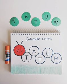 a spiral notebook with the word taum written on it next to an orange marker